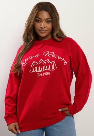 Roter Strickpullover mit gerippten Bündchen und Saum. Mit weißer Stickerei "Alpine Resort" und einem Bergdesign mit Bäumen. Lässige Passform.