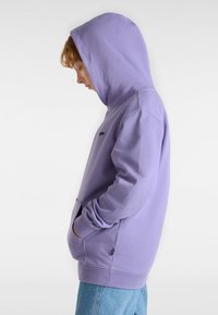 Lila Hoodie aus weichem Material, mit einer Kängurutasche, Kapuze mit Kordelzug und dezentem Logo auf der Brust.