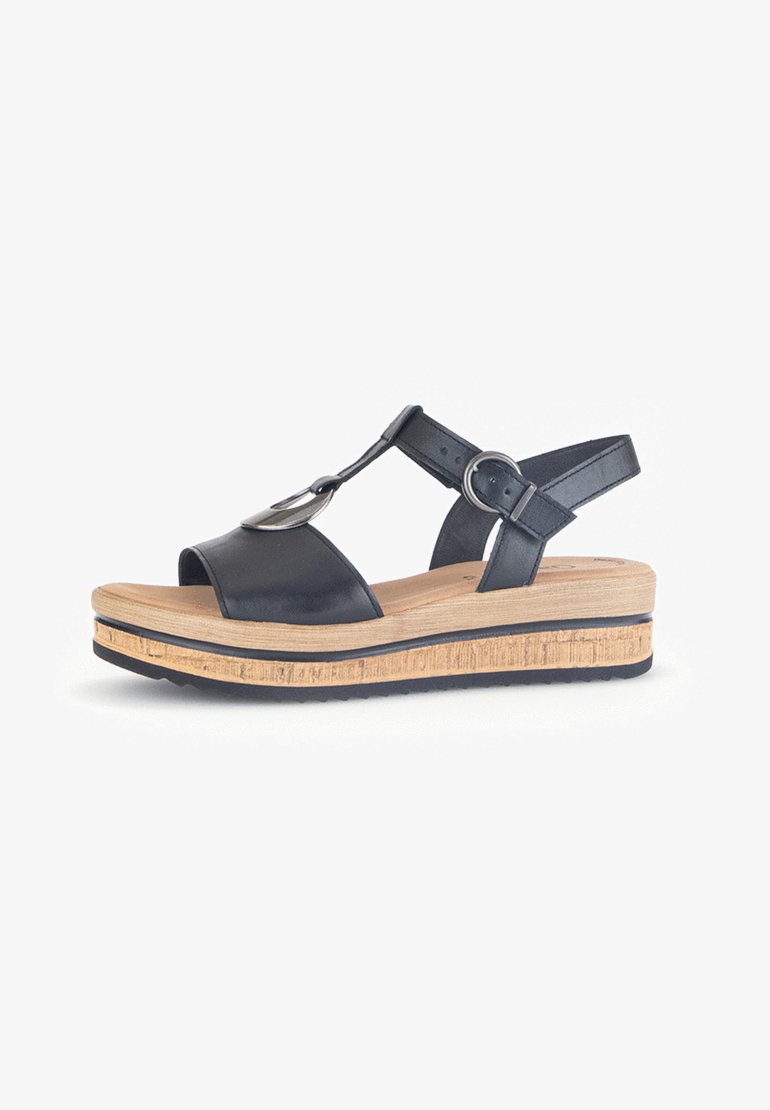Black leather wedge sandal with an adjustable ankle strap, open toe, metallic accent, and a textured natural wood platform.