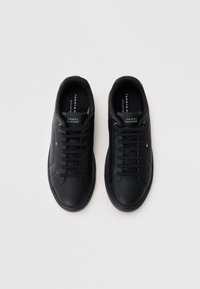 Czarne skórzane sneakersy o niskim kroju, z okrągłym noskiem, płaskimi sznurówkami oraz akcentami logo na języku i bocznej ściance.
