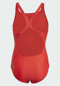 Bañador rojo con un diseño de espalda cruzada. Hecho de un material suave, con una espalda recortada y una sutil marca en el costado.