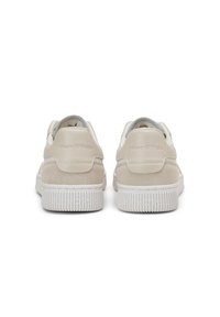 Beżowe zamszowe i skórzane sneakersy z teksturowaną białą gumową podeszwą, z subtelnym logo na pięcie i szarym wykończeniem.