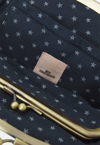 Navy fabric purse interior with white star pattern. Features a gold metal clasp and a fabric label reading "Beck Søndergaard."