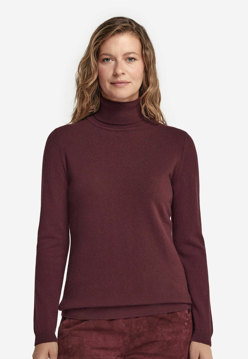 Burgundy polokrage tröja med långa ärmar, ribbade muddar och nederkant. Tillverkad av mjukt stickat tyg som visar en jämn och slät textur.