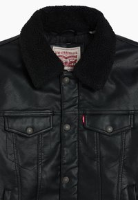 Black leather jacket with a black fleece collar. Features two chest pockets, button closure, and a red tag detail near the hem.