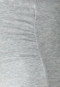 Hellegraue Sportleggings aus einem weichen, strukturierten Stoff. Sie verfügen über glatte Nähte und ein figurbetontes Design für Komfort und Flexibilität.