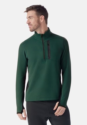 Pullover verde con zip realizzato in tessuto elasticizzato. Presenta una zip a un quarto e una tasca sul petto con zip nera. Texture liscia e vestibilità atletica.
