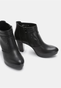 Black ankle boots made of smooth leather, featuring a perforated design on the sides, a chunky heel, and a side zipper for closure.