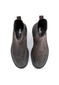 Stivaletti in suede marrone con suola in gomma nera. Presentano pannelli elastici per l'ingresso, fodera in tessuto e un'asola sul retro.