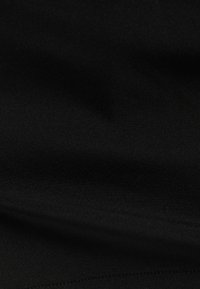 Černá látka s hladkou texturou, která má jemný lesk. Povrch je bez vzoru, s viditelným švem podél okrajů.