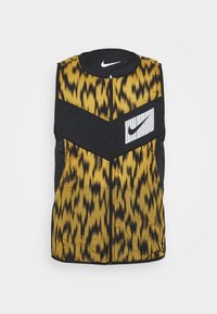 Wattierte Weste mit einem gelb-schwarzen Tiermuster, schwarzen Akzenten, Reißverschluss und einem Nike-Logo auf der Brust. Strukturierter Stoff.