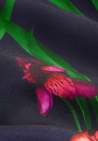 Bloemenstof met roze orchideeën en groene bladeren op een donkerblauwe achtergrond. Zachte textuur met een gladde afwerking en levendige kleuren.