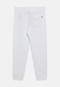 Pantalones de chándal blancos con cintura y puños acanalados, que cuentan con un único bolsillo trasero con un pequeño logo de Tommy Hilfiger en la esquina superior derecha.