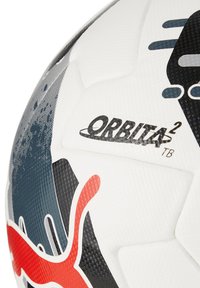 Palla da calcio bianca con accenti neri e rossi, caratterizzata da una superficie texturizzata e il logo "ORBITA2 TB." Design distintivo visibile.