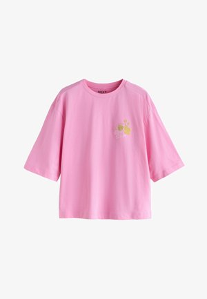 Vaaleanpunainen, lyhythihainen T-paita, valmistettu puuvillasta, jossa on kirjailtu "Slow Down" -kuvio kukkaistutuksia koristiessa paidan etuosaa.