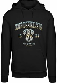 Sort hættejakke med et stort, metallisk "BROOKLYN" grafisk design, med et stiliseret "B" og teksten "New York City" i hvidt nedenunder.