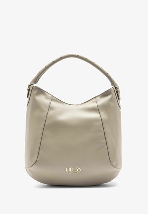 Világos bézs bőrből készült hobo táska kerek formával, tüskékkel díszített fogantyúval és arany bevonatú logóval az alján. Sima textúra.