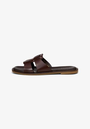 Sandale marron en cuir à enfiler, à bout ouvert, larges brides croisées sur le pied, avec une semelle plate en caoutchouc beige.