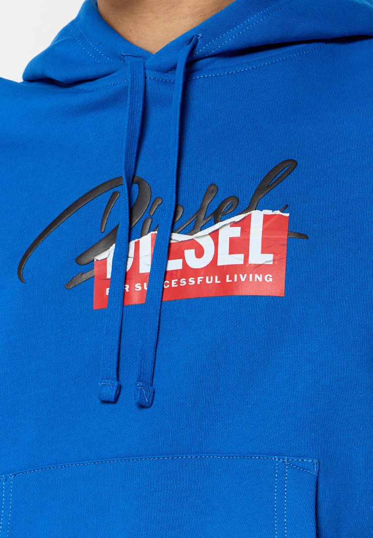 Sudadera azul de tela suave, con un bolsillo frontal, capucha con cordón y una impresión gráfica con la palabra "Diesel" en negro sobre un fondo rojo.