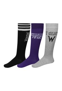 Tres pares de calcetines hasta la rodilla: negros con rayas blancas y texto, morados con "ADVERTENCIA TOXICO" y grises con elementos de diseño que dicen "SIN CORAZÓN Y FELIZ".