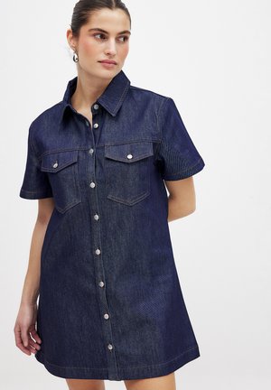 Denimhemdkleid mit kurzen Ärmeln, dunkelblauer Farbe, spitzem Kragen, durchgehender Knopfleiste, zwei Brusttaschen und kontrastierenden gelben Nähten.