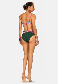 Kostium kąpielowy w kwiaty, z kolorowym wzorem kwiatowym, zielonymi majtkami w wysokim stanie, regulowanymi ramiączkami i pasującym akcesorium do włosów.