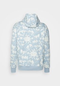 Felpa blu chiaro realizzata in tessuto morbido, caratterizzata da un motivo floreale bianco. Progettata con cappuccio e polsini a coste sia sul fondo che sulle maniche.