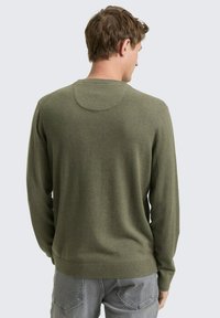 Zielony oliwkowy sweter z dzianiny, z długimi rękawami, okrągłym dekoltem, ściągaczami na mankietach i u dołu, miękka tekstura, dopasowany krój, widoczne szwy na ramionach i plecach.