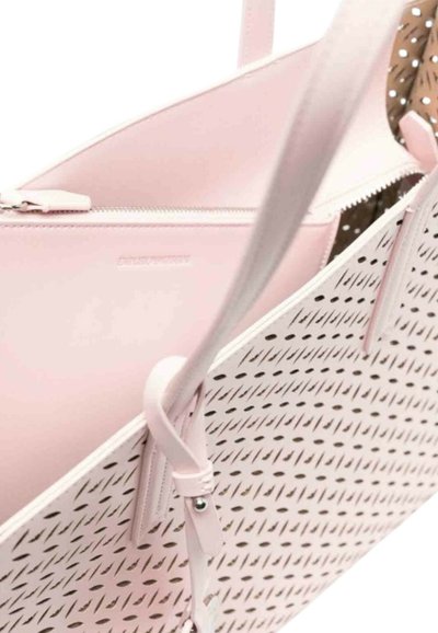 Una borsa a tracolla in pelle perforata pink con doppi manici e chiusura a zip. L'interno presenta un motivo a pois che crea un contrasto.