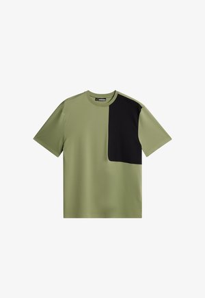 Oliwkowa koszulka z krótkim rękawem, z czarną prostokątną wstawką po lewej stronie, wykonana z gładkiego, lekkiego materiału.