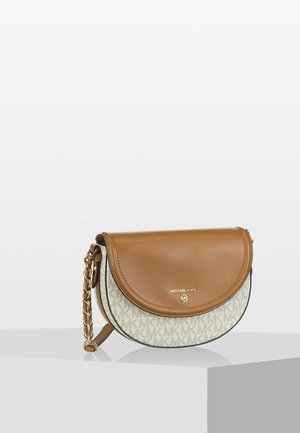 Half-moon shaped Michael Kors handbag with tan leather flap, beige monogram fabric, and gold chain strap on a white pedestal.