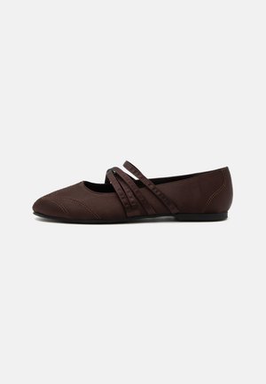Chaussure plate marron avec un bout pointu et deux fines brides croisées sur le cou-de-pied, détails de couture visibles et petit talon.