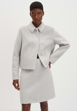 Graue Wollmischjacke mit Kragen und Druckknopfverschluss, kombiniert mit einem passenden Rock, der über dem Knie endet. Glatte Textur, minimalistisches Design.