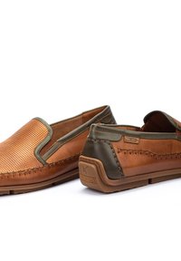 Bruine leren instap schoenen met geperforeerde details, groene accenten, contraststiksel en een rubberen zool. Pikolinos-logo op de achterkant.