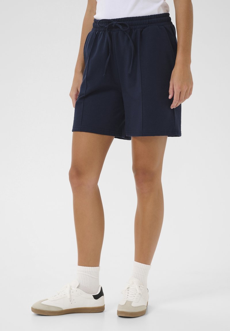 Shorts en mélange de coton bleu marine avec une taille élastique et un cordon de serrage. Comprend des poches latérales et une coupe décontractée.