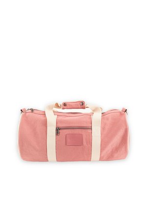 Bolsa de viaje cilíndrica de color rosa suave con asas color crema, bolsillo frontal con cremallera y agarre para el asa con botón a presión, colocada plana sobre un fondo blanco.