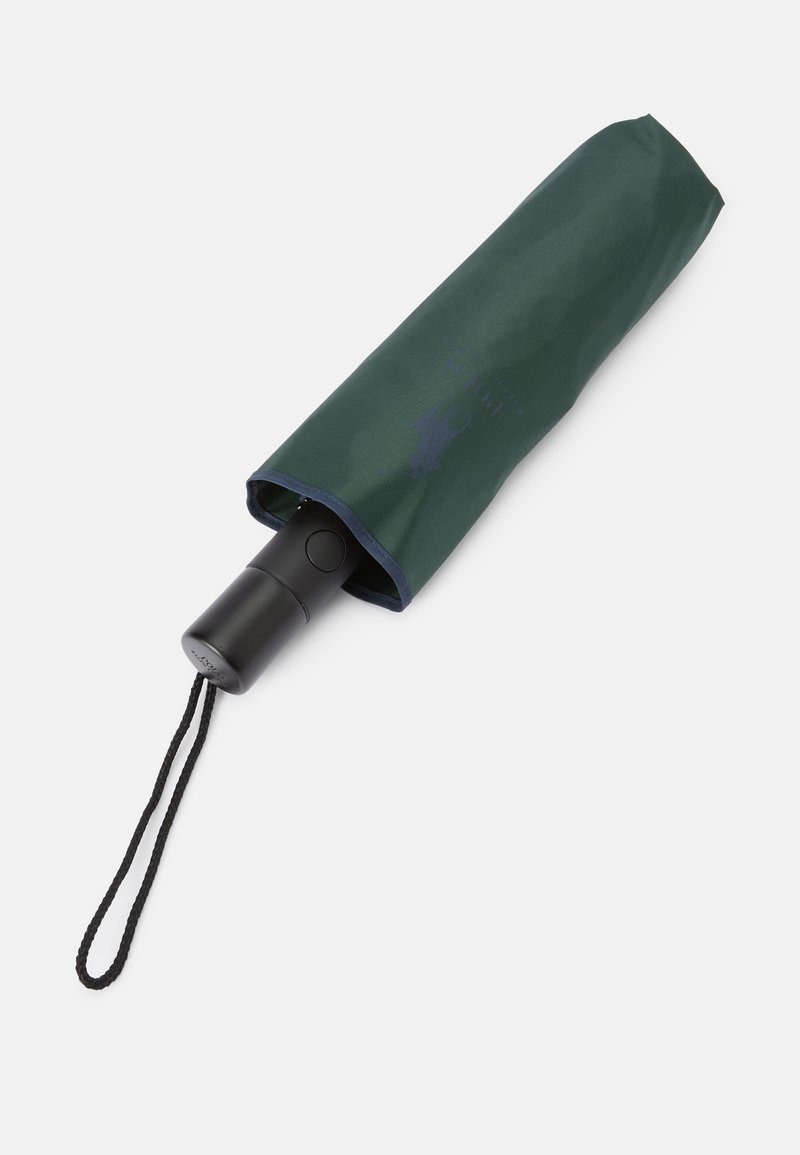 Zielona torba na parasolkę z czarnym uchwytem, wyposażona w mechanizm przyciskowy oraz czarny sznurek. Ciemnoniebieski detal na krawędzi u góry.