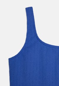 Débardeur bleu à côtes avec de larges bretelles, présentant un tissu tricoté texturé et un col rond. Design simple avec des bords nets.