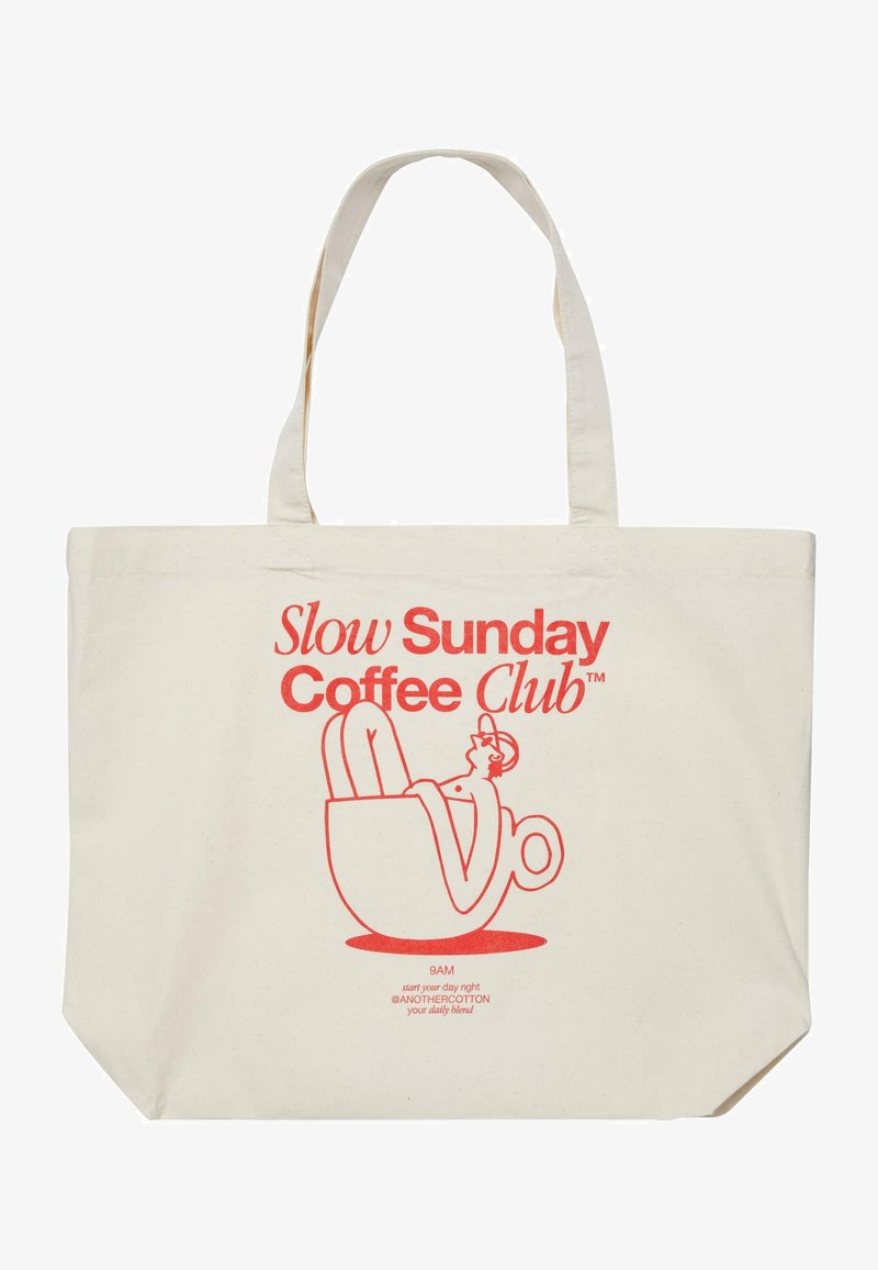 Kanvas torba v off-white barvi z rdečim grafičnim tiskom. Vsebuje besedilo "Slow Sunday Coffee Club" in risanico kavne skodelice. Dolgi ročaji.