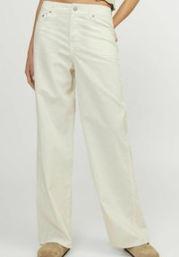 Pantalones de pierna ancha en color crema, con una tela suave, cinco bolsillos y un cierre de botón en la cintura.
