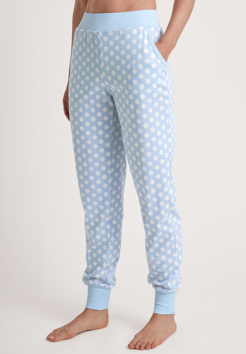 Lichtblauwe sweatpants met witte stippen, elastische tailleband, zijzakken en ribbelmanchetten bij de enkels. Zacht katoen materiaal.