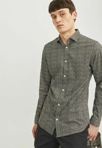 Chemise noire à boutons avec imprimé floral blanc, manches longues, col et ourlet droit. Fabriquée dans un tissu léger.