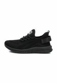 Zapatos deportivos negros con parte superior de malla transpirable, suela de goma texturizada y cordones ajustables con una correa de talón que proporciona soporte.