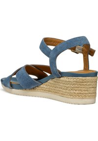 Blauwe suedewedged sandalen met kruislingse banden, een gestructureerd geweven jute platform en een gladde bruine binnenvoering met een verstelbare enkelriem.
