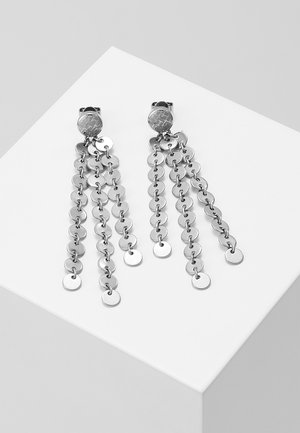 Boucles d'oreilles clips en métal ton argent avec trois chaînes pendantes composées de petits disques ronds reliés entre eux.