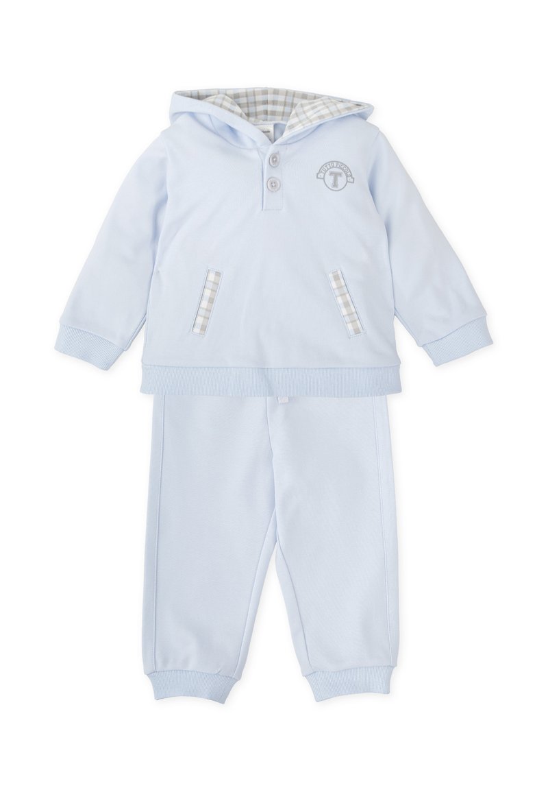 Chándal infantil azul claro con capucha, que cuenta con dos bolsillos delanteros con forro de cuadros, tapeta con botones y puños elásticos en los pantalones.