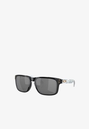Lunettes de soleil noires rectangulaires avec verres gris, dotées d'une branche à motif blanc et gris. Accents dorés sur la monture, matériau en plastique lisse.