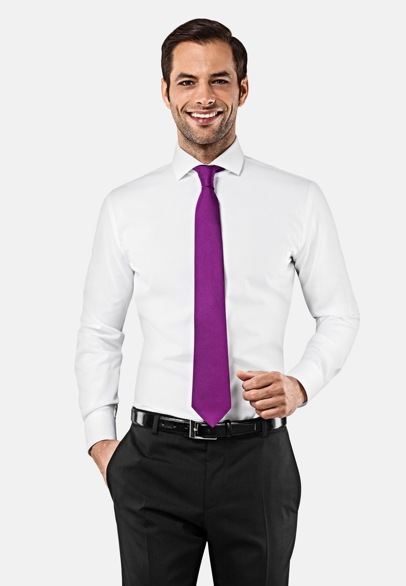 Witte overhemd met lange mouwen, gecombineerd met een gestructureerde paarse stropdas en zwarte pantalon, vastgehouden door een zwarte riem.