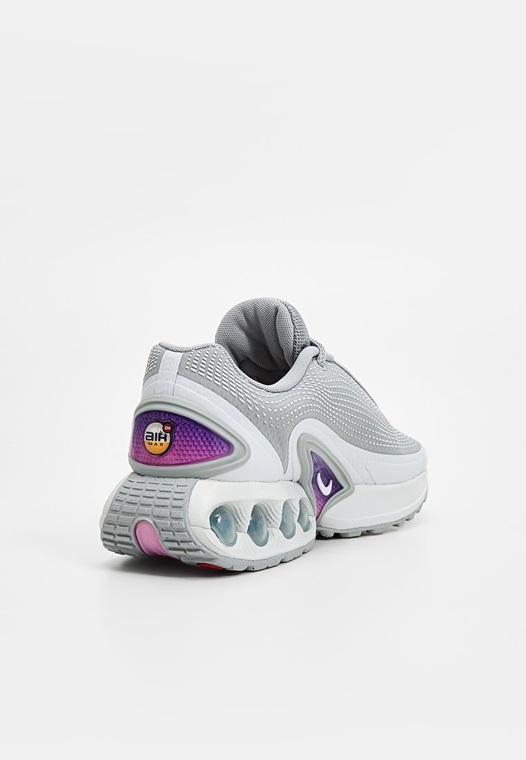 Chaussure de sport en maille grise avec une touche de violet, talon arrondi et design de semelle avec coussin d'air visible. Tige texturée pour la respirabilité.