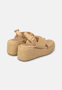 Sandali piattforma beige con cinturini in tessuto intrecciato, una soletta in pelle liscia e una suola avvolta in juta testurizzata. Chiusura con fibbia regolabile.